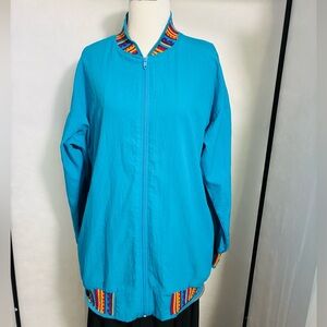Blue windbreaker with colorful detail on cuffs, collar and waistband.